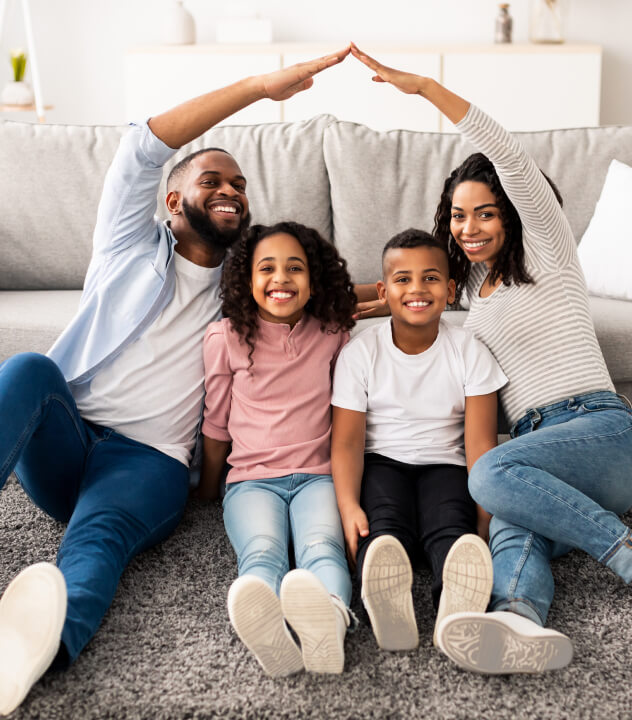 family smiling for portrait in living room