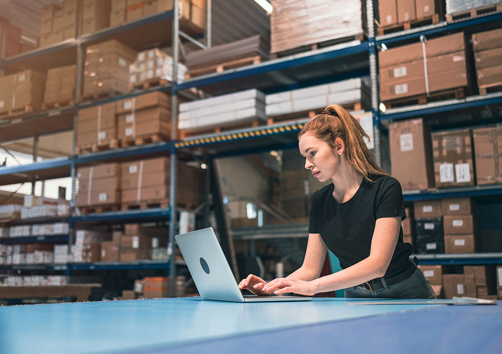 women on laptop in warehouse