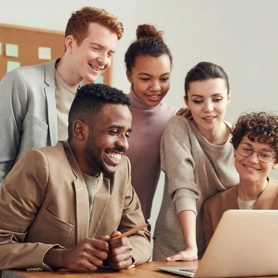 team doing research on laptop smiling